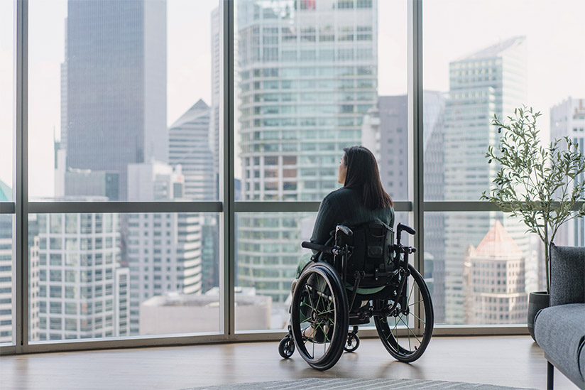 Disabled woman in wheelchair enjoying the view from her high rise apartment